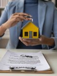 Woman holding a house figurine